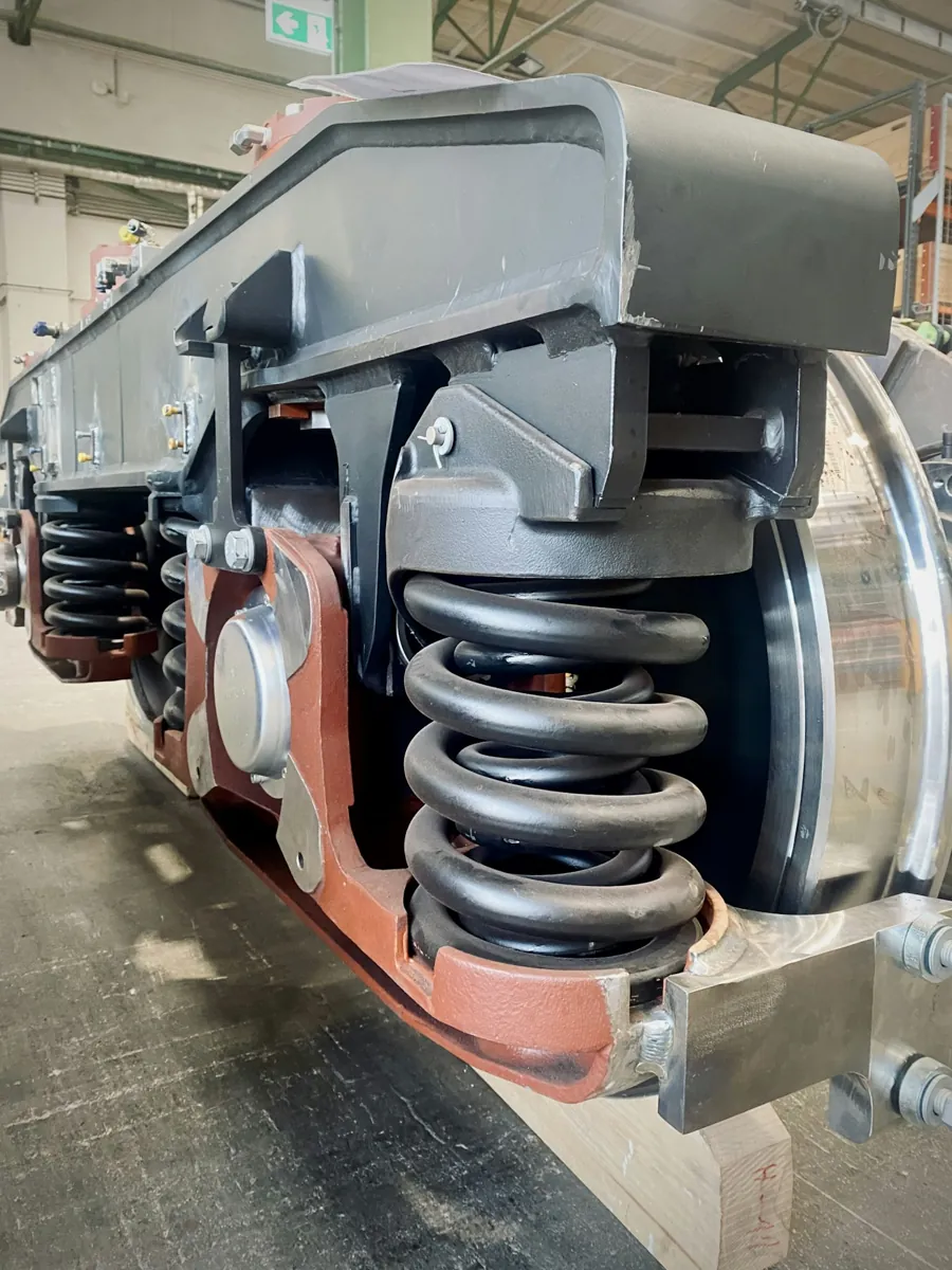 Close view of wheel, spring and suspension components on industrial rail equipment