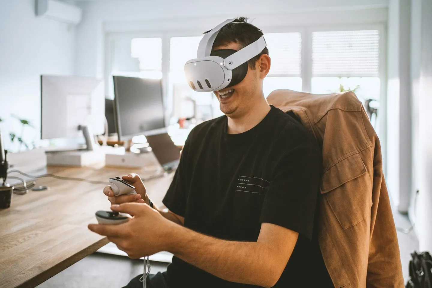 Seated participant wearing a virtual reality headset and holding two controllers